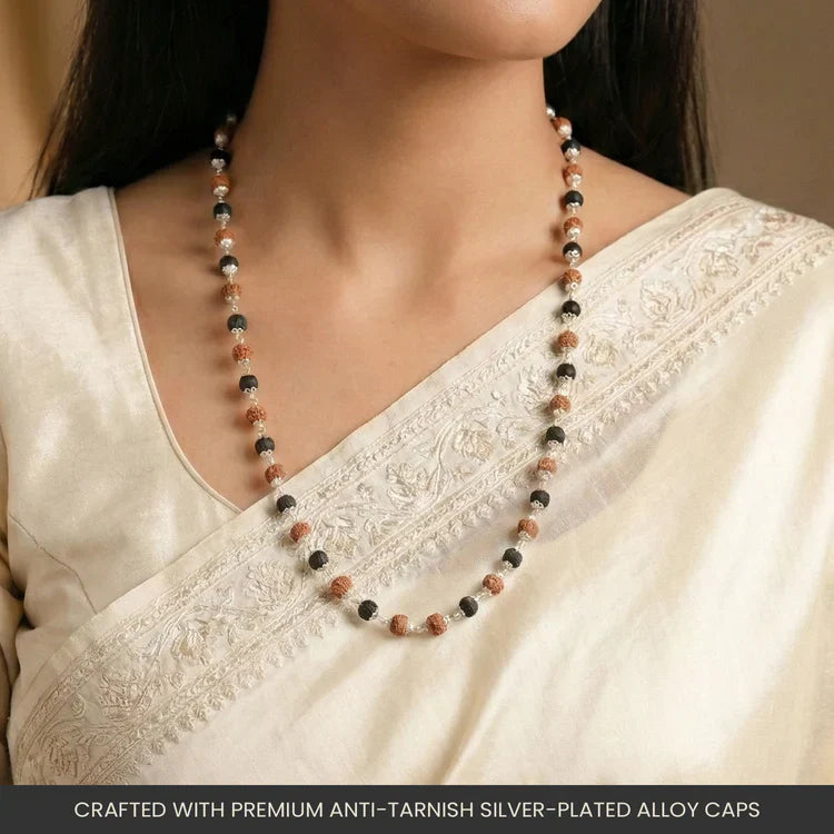Rudraksha and Karungali mala with silver-plated alloy capping worn around the neck over a cream saree