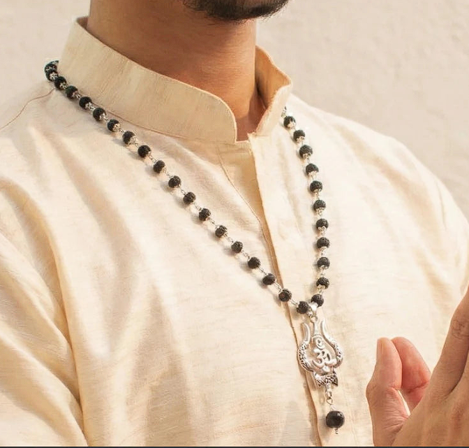 Karungali mala with Om Shiva Trishul pendant worn around the neck over a cream kurta